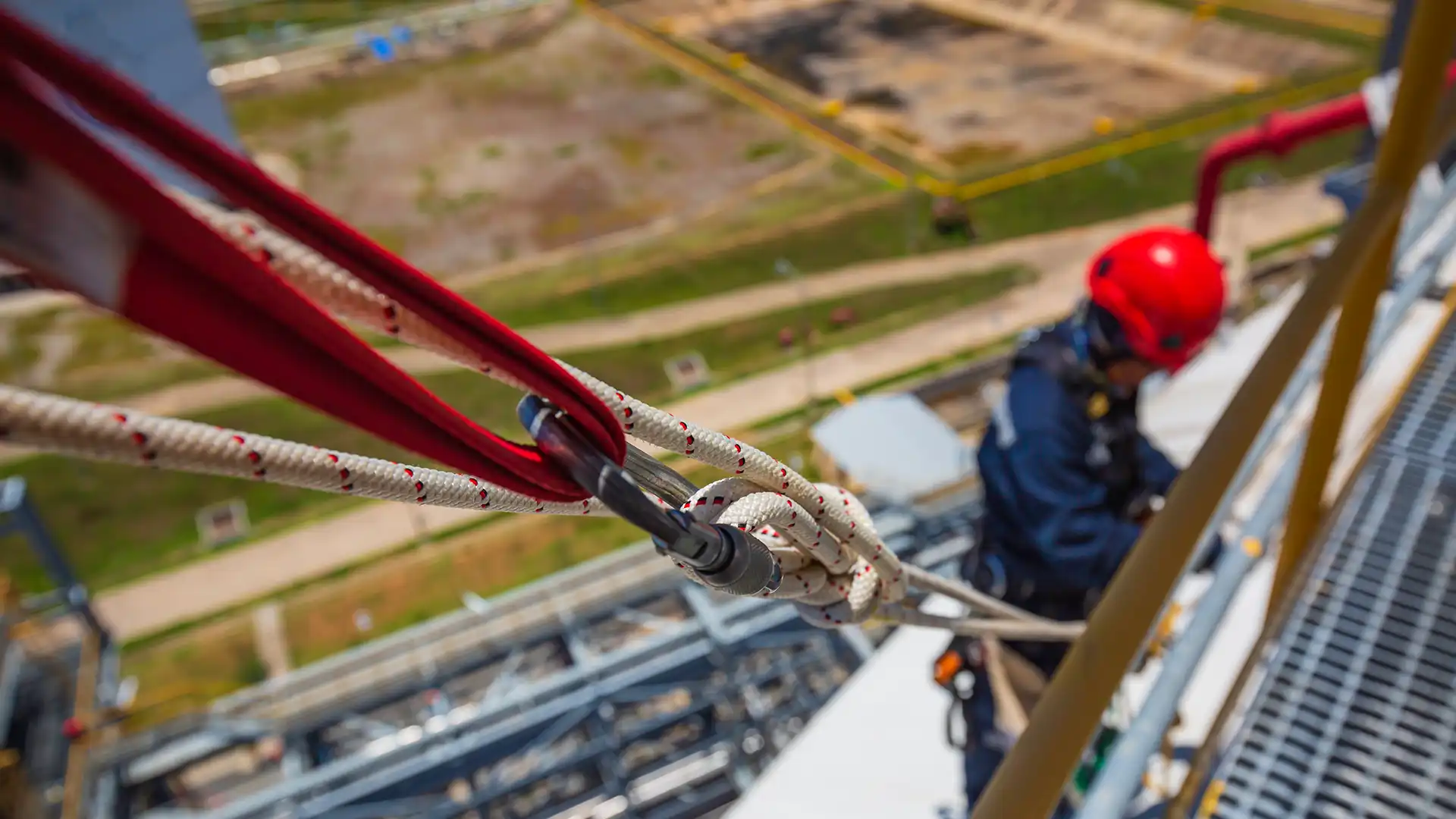 Emniyet kemeri ve lanyard kullanarak yüksekte çalışan bir işçi
