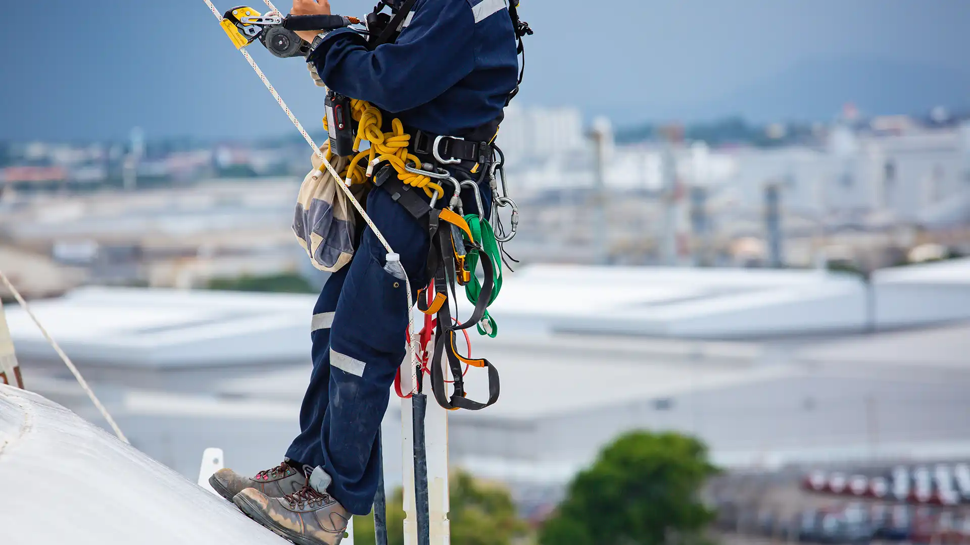 Emniyet kemeri, karabinalar ve farklı lanyard türleriyle çatı yüzeyinde çalışan bir uzman