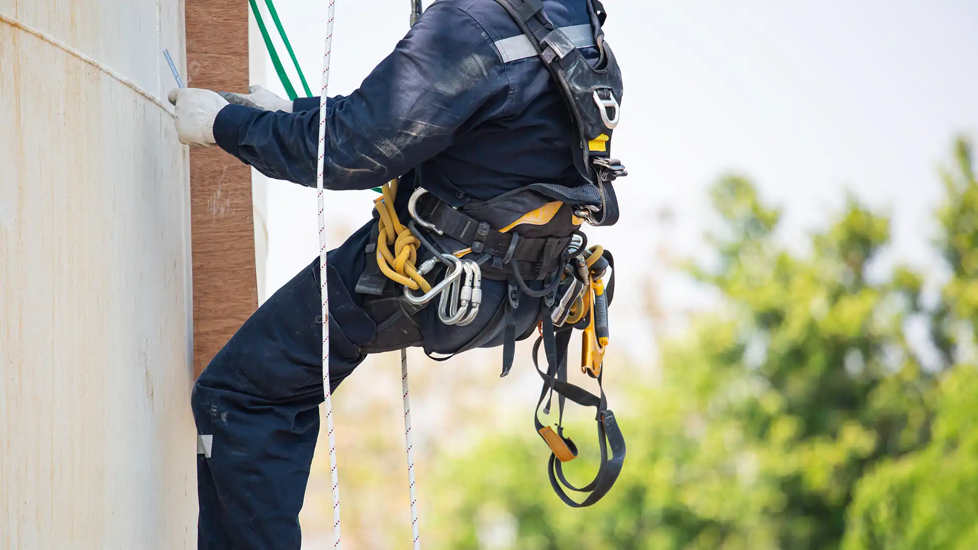 Şok emicili lanyard ve emniyet kemeri kullanan yüksekte çalışan işçi
