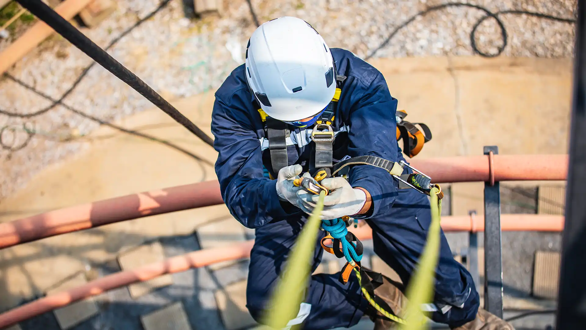 Yüksekte çalışan işçi geri sarımlı düşüş durdurucu ve emniyet kemeri kullanıyor